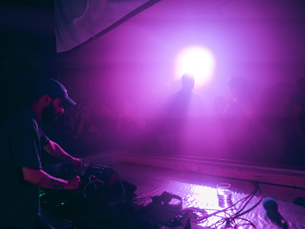 Image of analogged_out performing a hardware set to a crowd under purple lighting